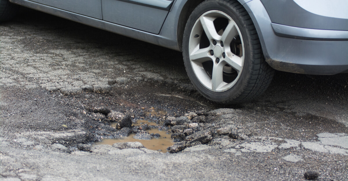 Car wheel by pothole